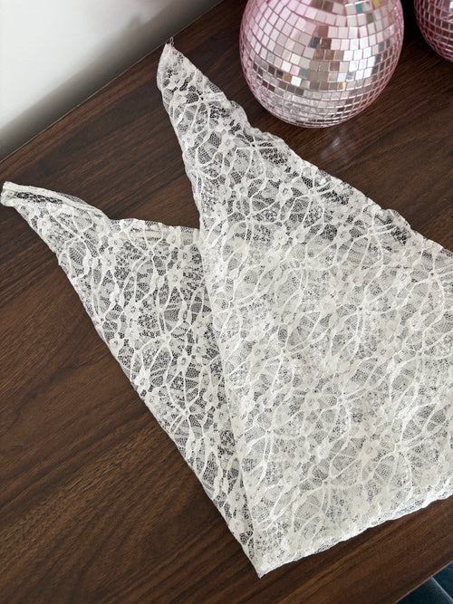 bandana en dentelle blanche plissé et posé sur une table en bois