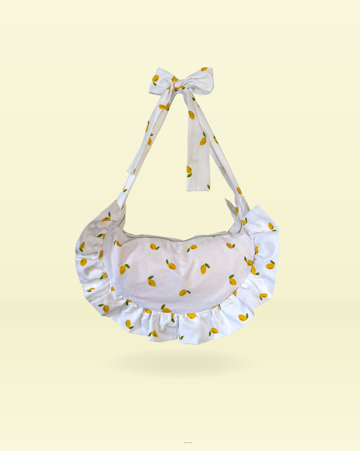 sac à main blanc forme demi-lune à froufrous motif mini citrons