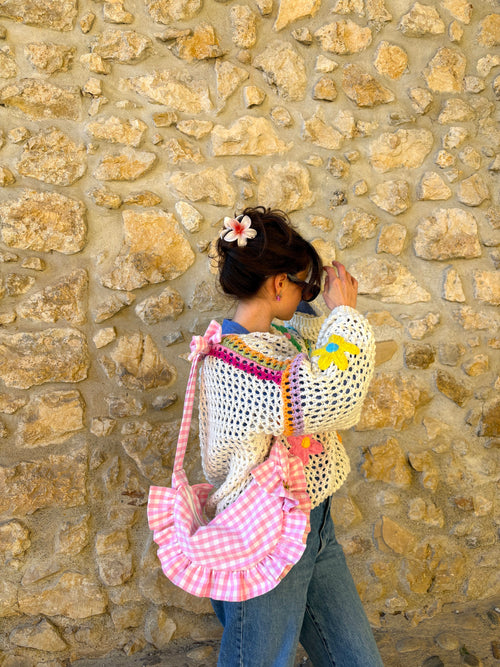 Sac à main à volants en forme de demi-lune/croissant, fait main, coloris Cerisier, collection Printemps, porté par une jeune femme de profil en tenue colorée